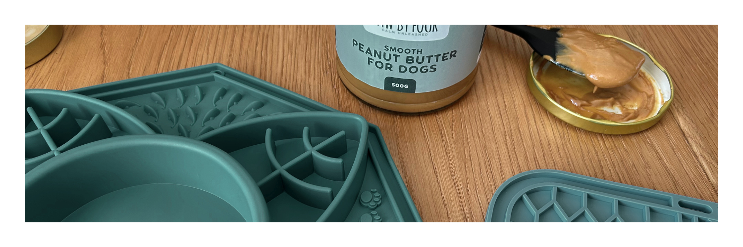 Paw by Four's Peanut butter for dogs being applied to a lick mat with a jar of peanut butter and a spoon.